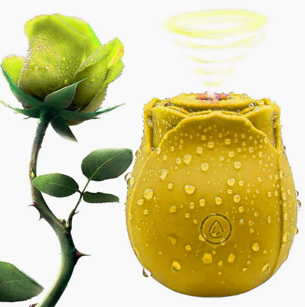 Yellow rose-shaped waterproof couples game accessory with water droplets, next to a real rose stem.